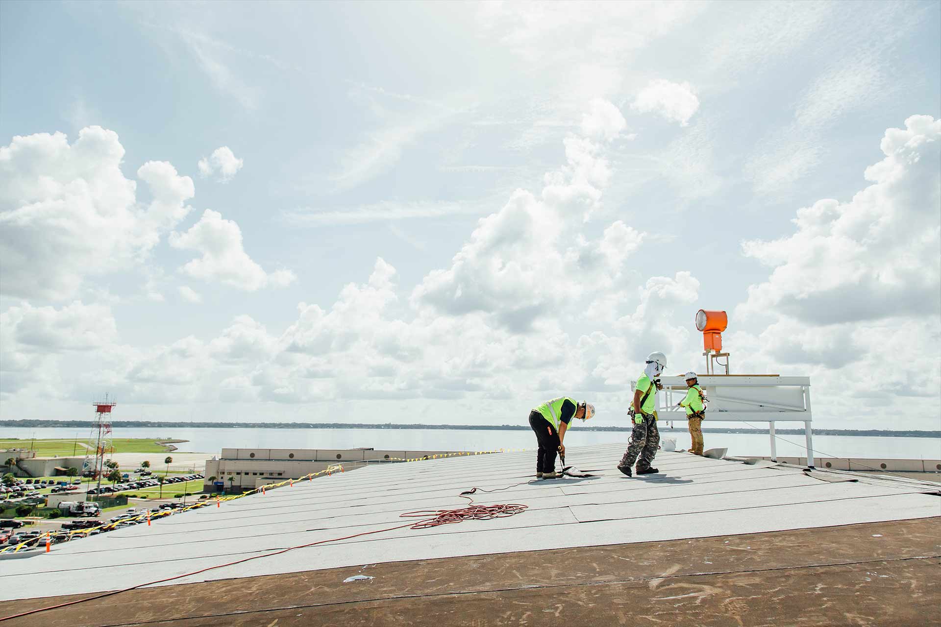 Register Roofing Employees Installing a New Roof on The F-18 Hangar at Naval Air Station Jacksonville.
