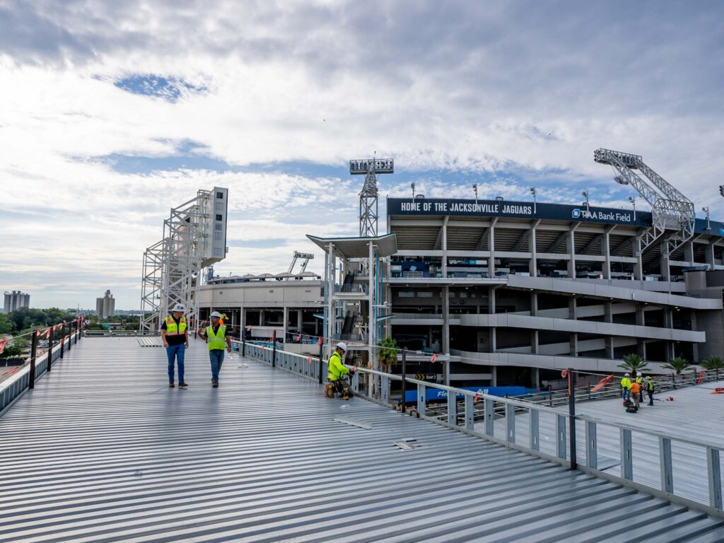 Register Roofing Employees walking on the new jaguars training facility commercial roof
